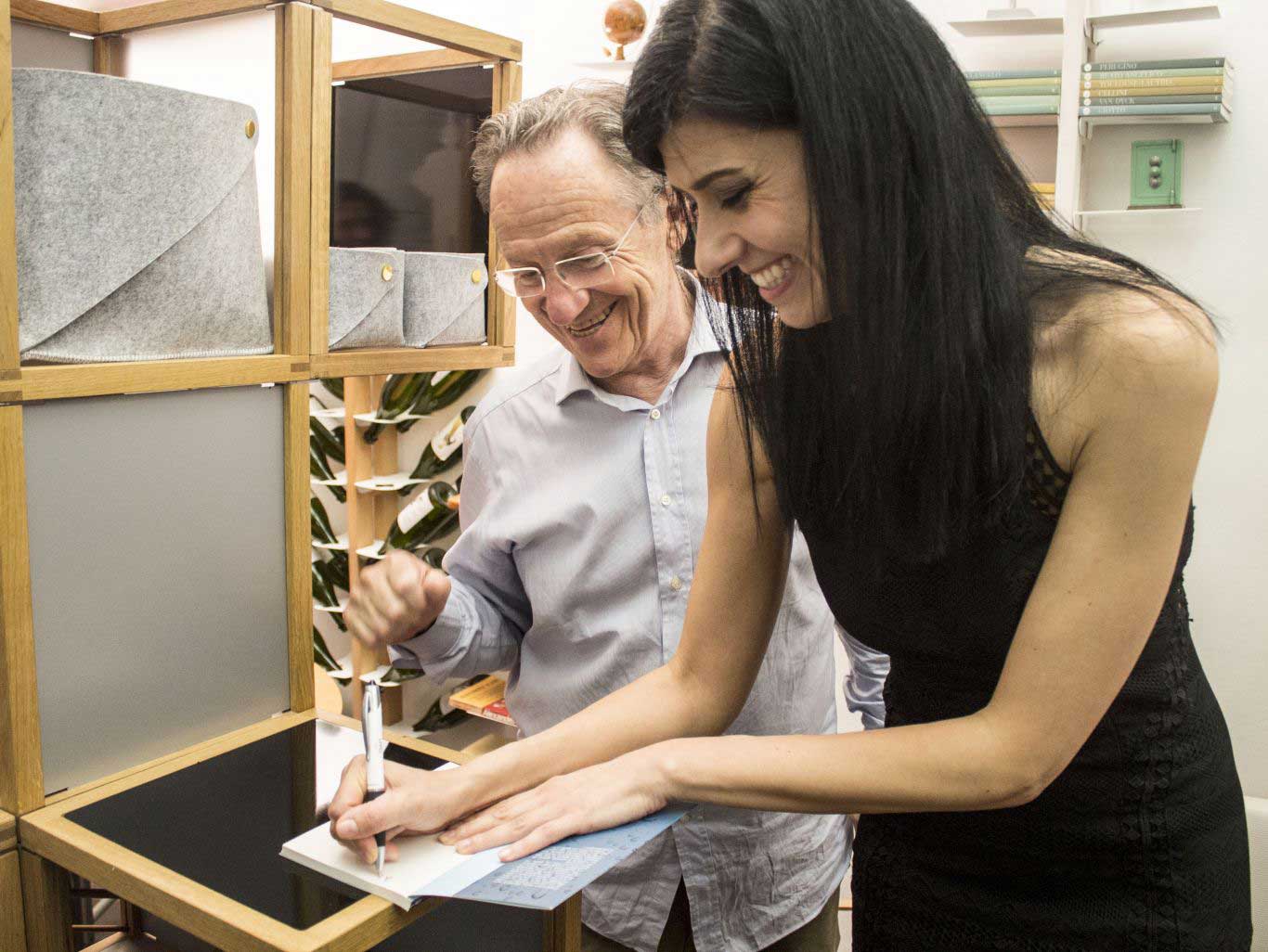 Maddalena Baldini firma una copia del libro "Storie di una degustatrice astemia" a Marcello Vecchi durante la presentazione presso lo showroom de Le Zie di Milano